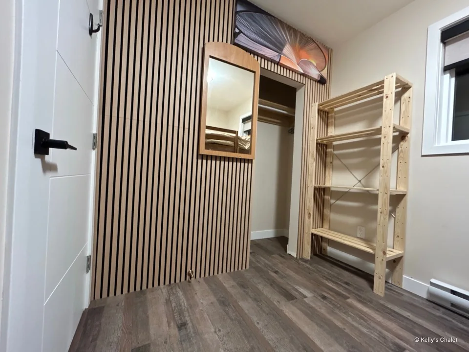 Mirror, timber feature wall and open wardrobe in Bedroom II at Kelly’s Chalet
