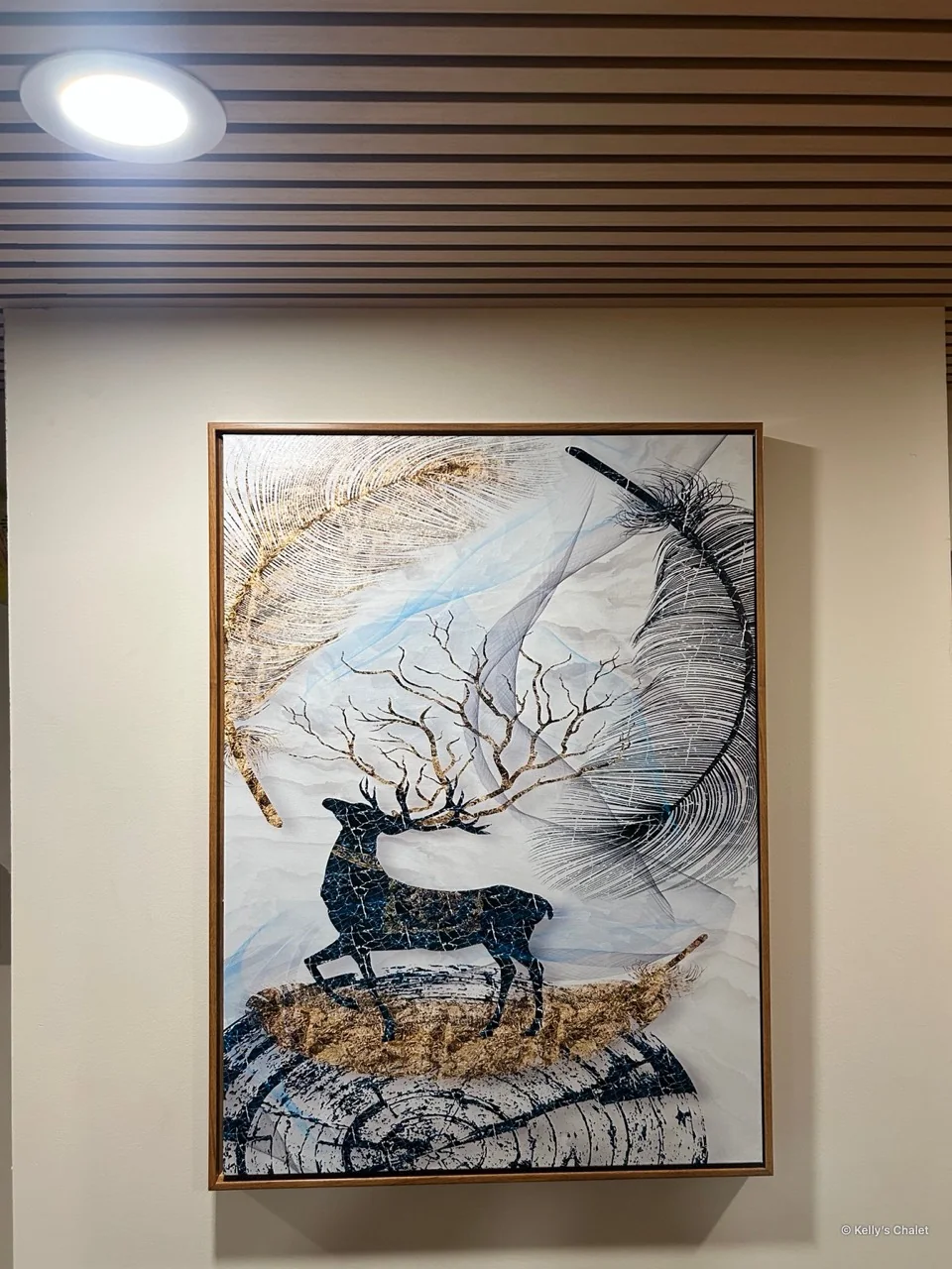 Framed deer artwork beneath the main bedroom’s timber ceiling