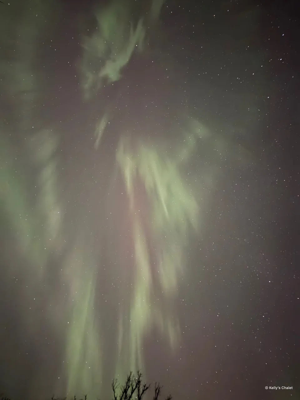 Green and pink aurora curtains in the Grand Beach area, photographed away from Kelly’s Chalet