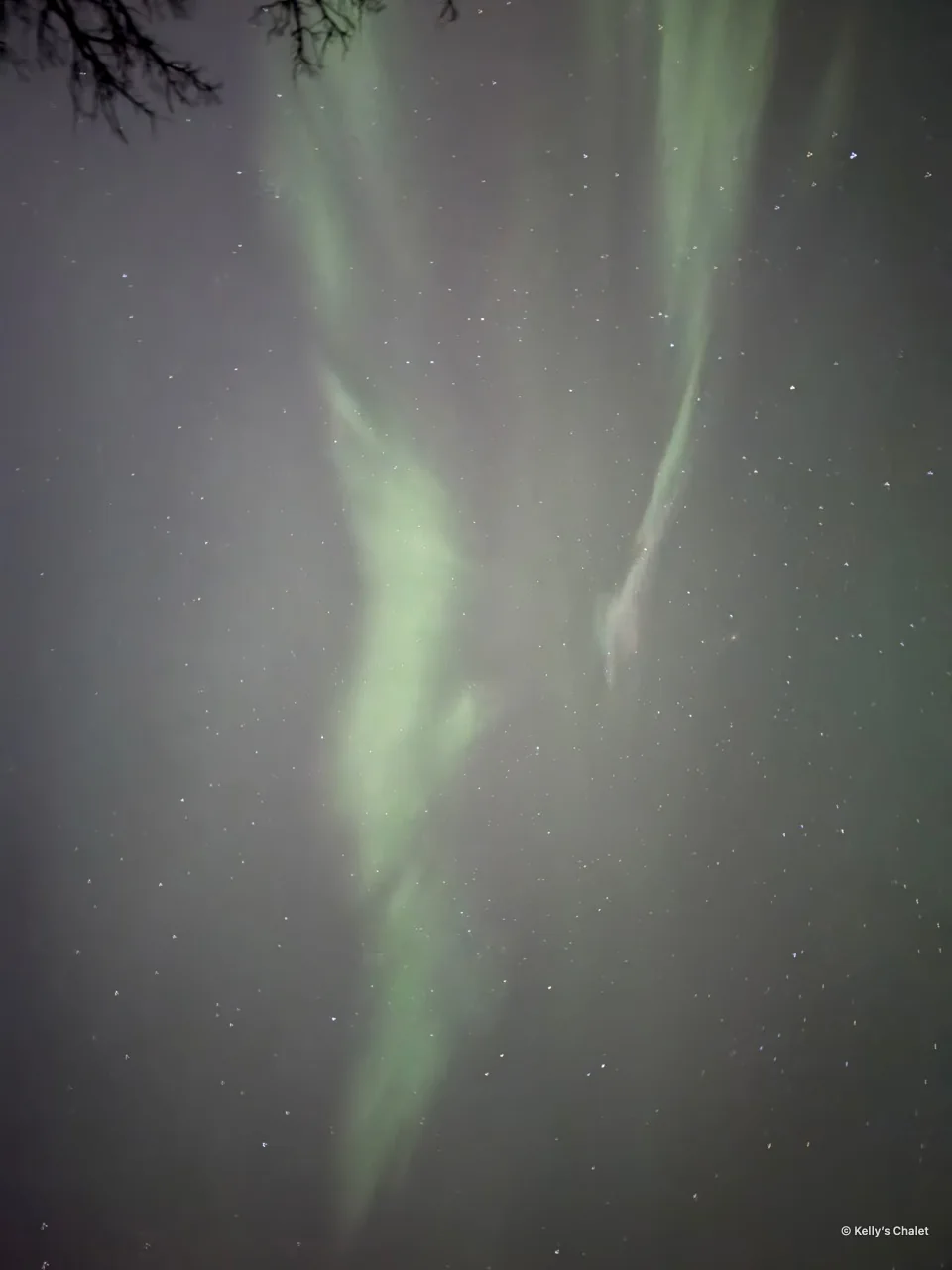 Green aurora stretching across the night sky in the Grand Beach area, photographed away from Kelly’s Chalet