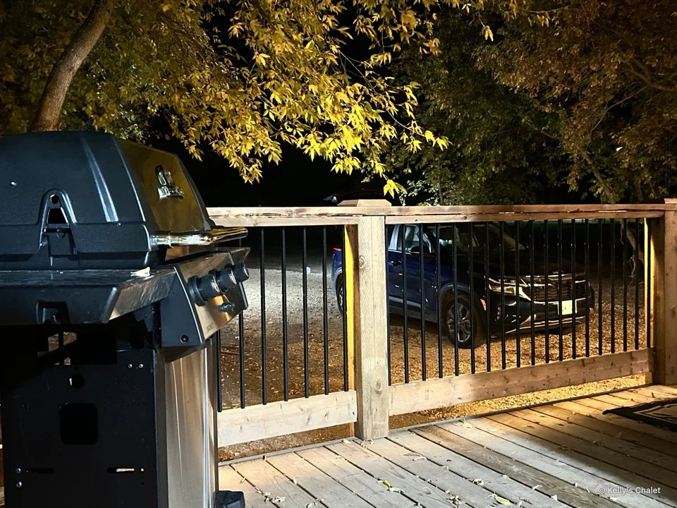 The chalet deck and barbecue under warm evening lights