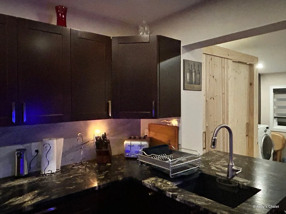 The chalet kitchen counter, sink and tap under warm evening lighting