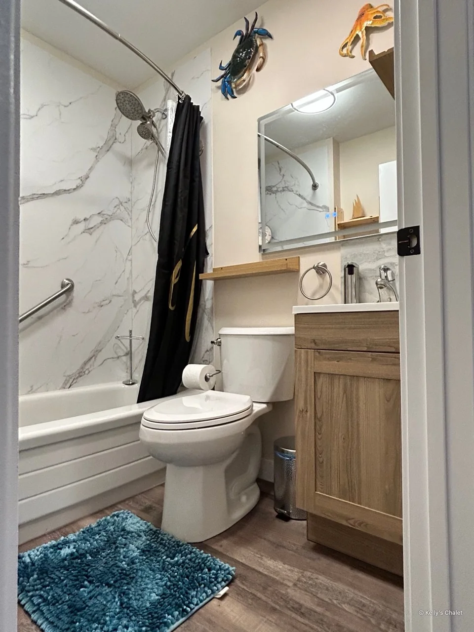 The chalet’s washroom with bathtub, shower curtain, toilet and vanity