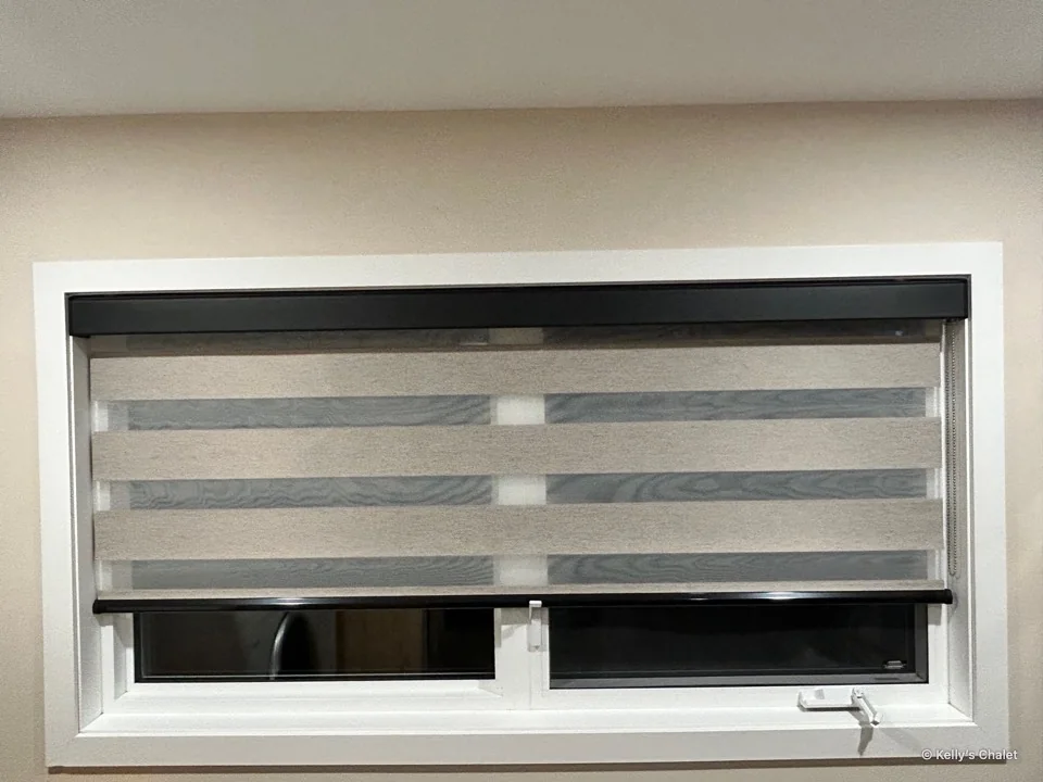 Kitchen window with a striped roller blind