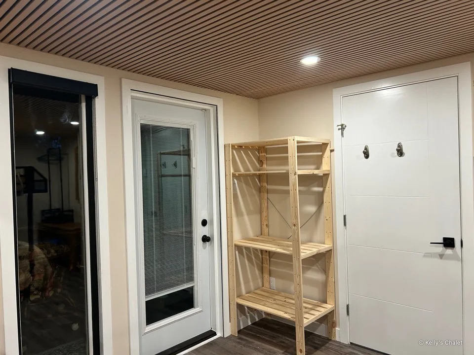Main bedroom wardrobe, doorway and window beneath the timber ceiling