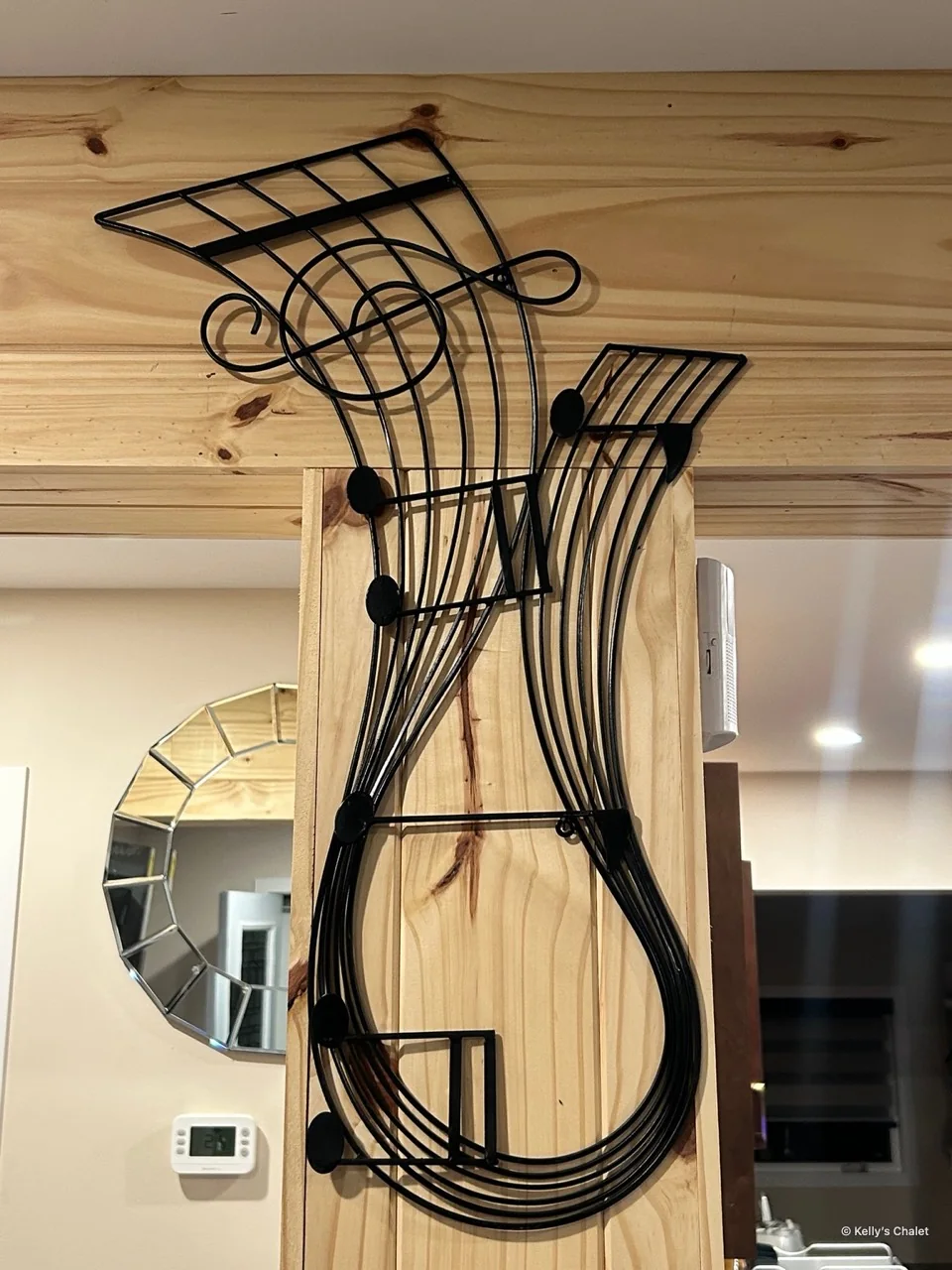 Musical metal wall artwork on a timber post