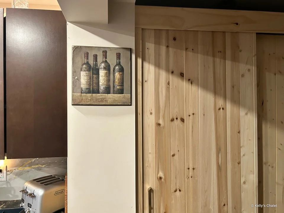 Timber kitchen doors beside framed wine bottle artwork