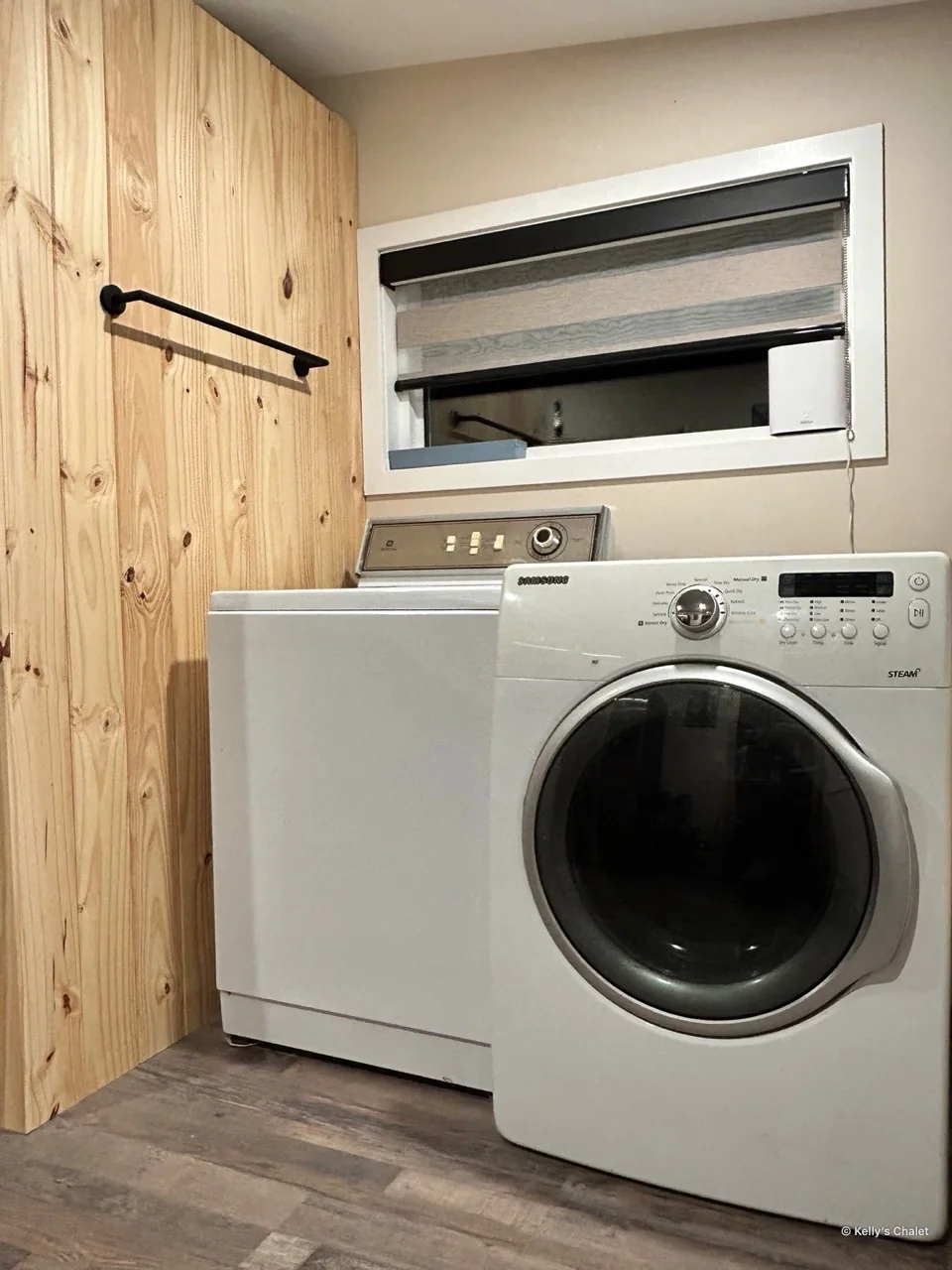 Washer and dryer beside a timber wall and window in the chalet