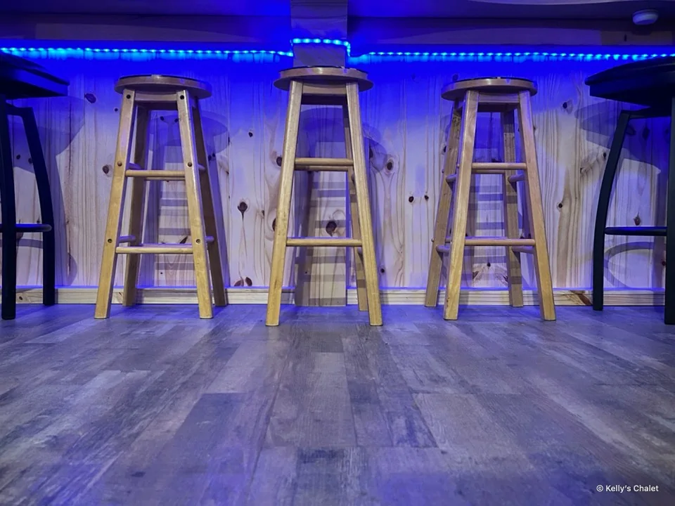 Wooden bar stools beneath blue counter lighting