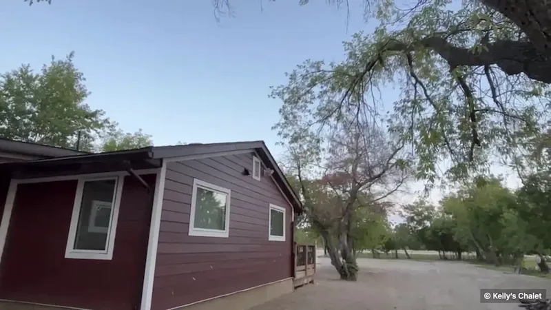 The burgundy chalet among trees in Grand Marais